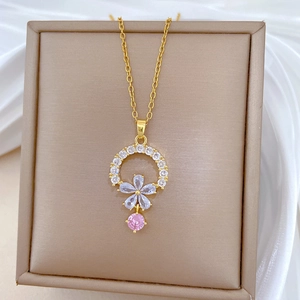 Detailed close-up of a floral pendant with pink zircon tassels on a gold titanium necklace