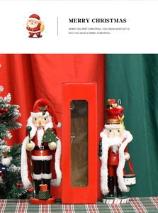 Detail showing two wooden Nutcracker Santa figures in a festive red window display box
