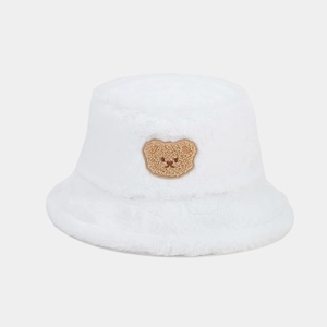 Close-up of soft white plush fabric and cute brown bear embroidery on the bucket hat