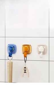 Detail showing adhesive wall hooks in blue, orange and white with gold accents