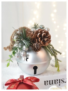 Close-up of silver Christmas bell with natural pine cone and rustic hemp rope hanger