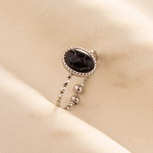 Macro shot of silver stainless steel adjustable ring with oval black patterned stone