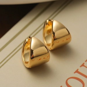 Detail of minimalist gold plated triangular hoop earrings with a polished smooth finish