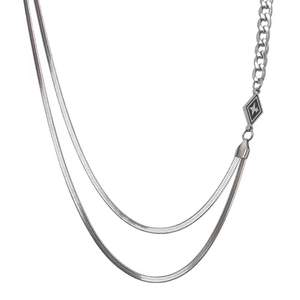 Detail of silver double-layer necklace with snake chain, Cuban links and star pendant