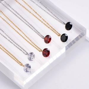 Diamond necklaces with round pendants in red, black, and clear stones on display