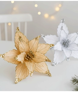 Close-up of 25cm sequined Christmas flowers with warm festive lights and greenery