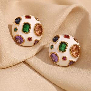 Detailed macro of gold plated dome earrings with white enamel and colorful crystals