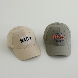 Detail of cotton twill baseball caps with NICE letter embroidery in beige and olive