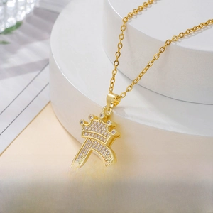 Macro shot of gold D letter pendant with crown design and white zircon inlays