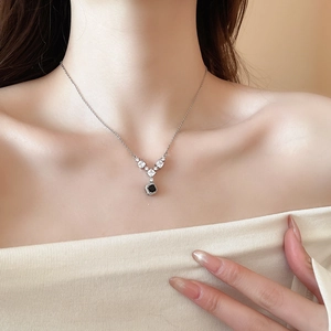 Dettaglio di collana a V in argento con gemma nera quadrata e zirconi brillanti sul collo
