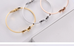 Three-color butterfly open bangles in gold, silver and rose gold on a white podium