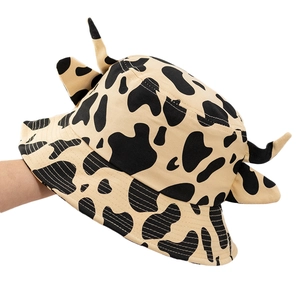 Cute cow print bucket hat with 3D horns and ears shown from a stylish side view angle