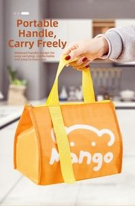 Detail of orange insulated lunch bag with mango bear logo and wide yellow fabric handle