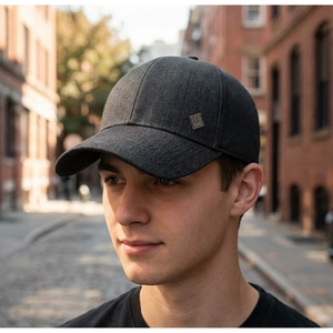 Detail of dark grey men's baseball cap featuring a metal logo on premium textured fabric