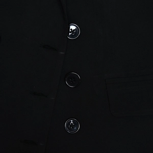 Détail de la texture du tissu noir et des trois boutons à quatre trous de la veste robe
