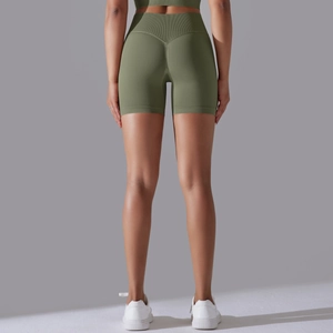 Detail view of olive green high-waist yoga shorts with ribbed band and V-seam contour