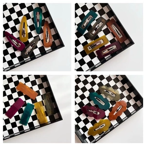 Elegant wavy jelly-textured hair clips in deep vintage colors for women on checkered tray