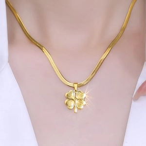 Élégant collier trèfle à quatre feuilles doré sur une chaîne serpent porté par un mannequin