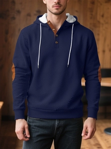 Dettaglio felpa con cappuccio blu navy in maglia a nido d'ape con toppe marroni