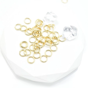 Real gold-plated copper jump rings for DIY jewelry making on white geometric base