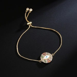 Adjustable evil eye bracelet in gold finish with colorful zircon stones on black background