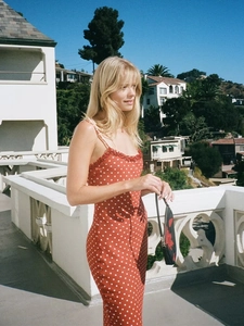 Nahaufnahme von rotem Polka-Dot-Kleid mit Spitzenbesatz und bestickter Clutch-Tasche