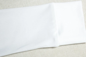 Gros plan sur les poignets blancs et la texture élastique fine de cette robe chic