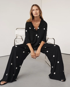 Close-up of black polka dot short-sleeve shirt and wide-leg trousers in draping fabric