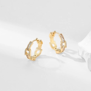 Detailed close-up of gold chain-textured hoop earrings with sparkling zircon gemstones
