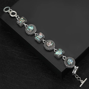 Silver chain bracelet with natural abalone shell inlay on black geometric display
