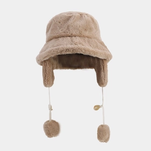 Detail of soft plush winter bucket hat with ear flaps and fluffy pompom drawstrings