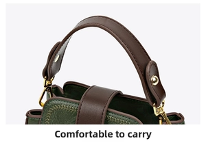 Detail of comfortable handle with green leather texture and gold hardware on bucket bag