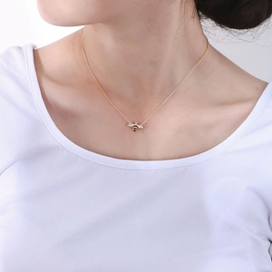 Detailed close-up of a golden S925 sterling silver honey bee pendant on a female model