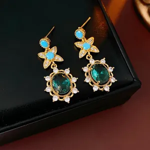 Vintage gold-plated drop earrings with oval green gemstones and star flower details