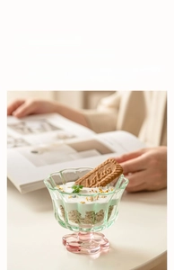 Détail de la tasse en verre en forme de pétale avec bord ondulé et base rose