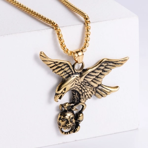 Golden eagle and skull pendant necklace on white geometric stand with bead chain