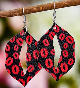 Detail of leaf-shaped faux leather earrings with red lip prints on black lychee texture