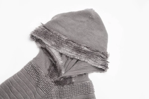 Close-up of grey knitted shawl detail featuring soft faux fur trim and textured weave