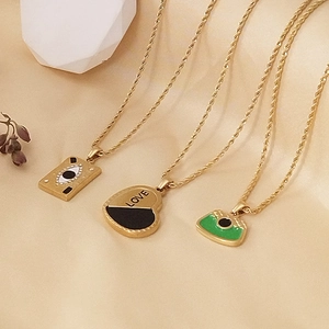 Detailed view of Bohemian gold necklaces featuring LOVE heart and enamel eye pendants
