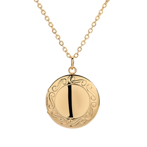 Macro detail of a golden vintage round locket pendant with intricate spiral relief pattern