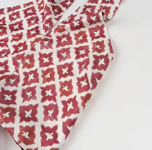 Close-up detail of red and white floral geometric pattern on high waist cotton fabric