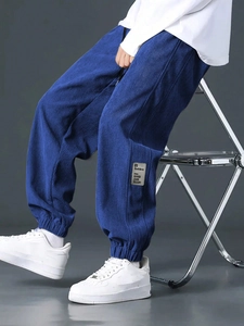 Detail of dark blue corduroy cargo pants with textured fabric and leg pocket embroidery