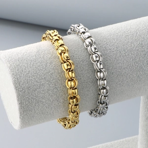 Polished gold and silver industrial chain bracelets on a professional jewelry display stand