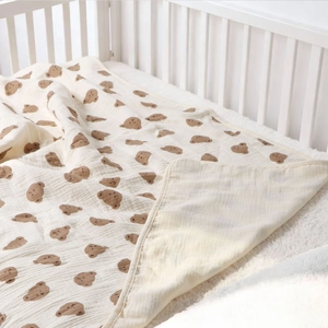 Detailed view of soft cotton baby blanket with brown cartoon bear print and neat edging