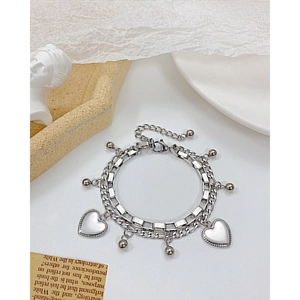 Detailed macro view of silver-tone double-layer stainless steel heart and bead bracelet