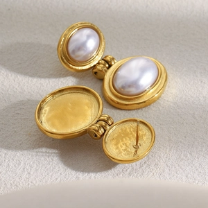 Detail view of 18K gold plated geometric earrings with large white oval pearls