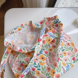 Detail of floral canvas tote bag showing watercolor flower prints and fabric texture