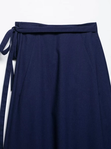Detailed view of dark blue midi skirt featuring elegant side bow-tie waist design