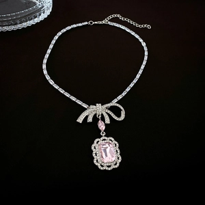 Détail du collier noeud argenté avec un grand pendentif en pierre rose rectangulaire