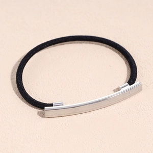 Macro detail of elastic hair tie featuring a brushed silver curved metal decorative bar